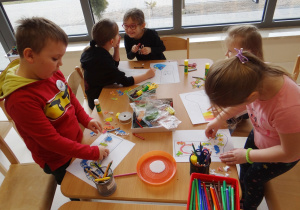 Dzieci wykonują przy stoliku skarpetę według własnego projektu.